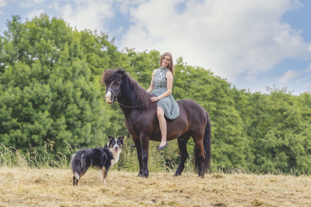Reiterin auf Islandpferd mit Border Collie stehend an ihrer Seite auf offener Wiese – Tierfotograf Trier Luxemburg Bitburg Zeeland